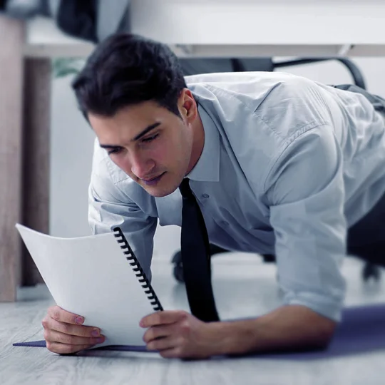 Mann mit Krawatte macht Plank im Büro